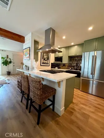 a kitchen with stainless steel appliances granite countertop a table chairs sink and stove