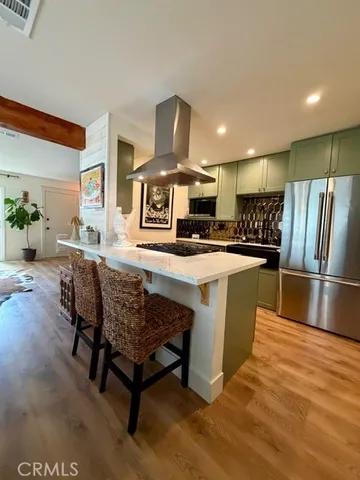a kitchen with stainless steel appliances granite countertop a table chairs sink and stove