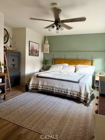 a bedroom with a bed and a mirror on the dresser