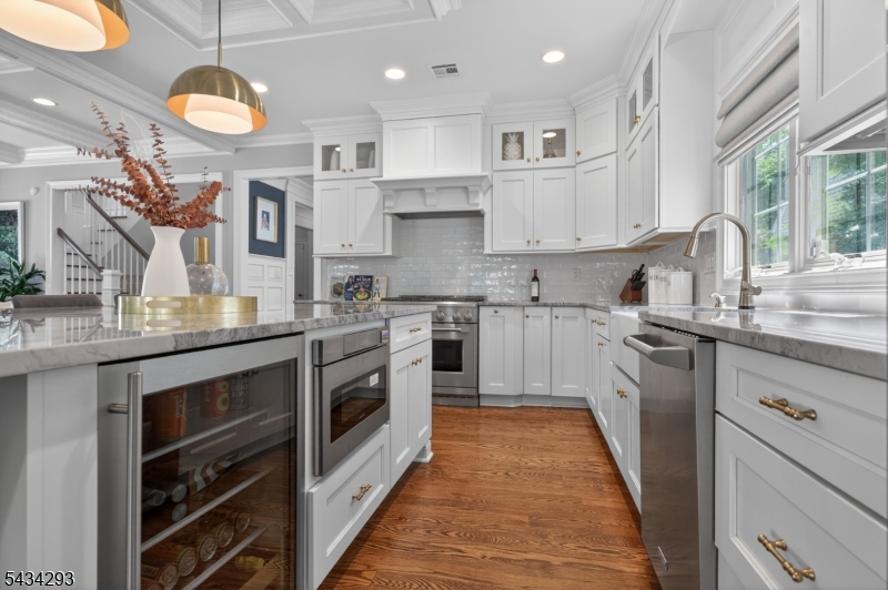 921 Harding Street Westfield, NJ 07090 - Photo 19 of 50 a kitchen with stainless steel appliances granite countertop a stove a sink dishwasher and white cabinets with wooden floor