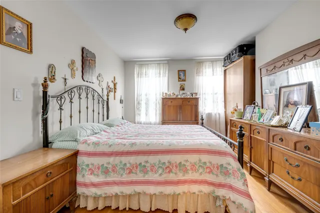 a large bedroom with a bed and a flat tv screen on dresser
