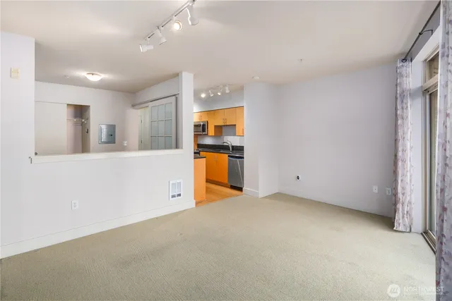 an empty room with a kitchen view and a window