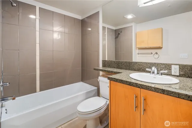 a bathroom with a granite countertop sink toilet and shower