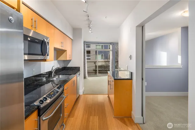 a kitchen with granite countertop a stove and a refrigerator