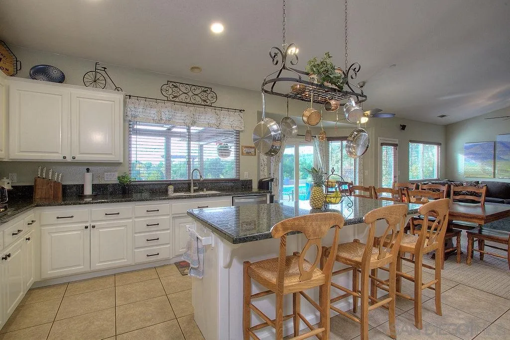 31028 Saddleback Road Valley Center, CA 92082 - Photo 3 of 21 a kitchen with cabinets a sink dining table and chairs