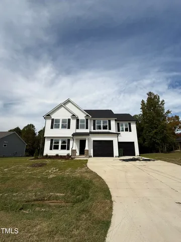 a view of a house with a big yard and large trees