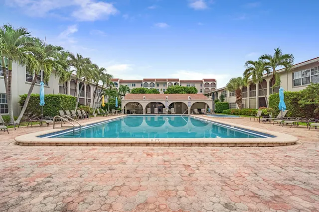 a view of a house with a yard and potted plants