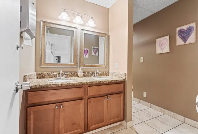 a bathroom with a granite countertop sink and a mirror