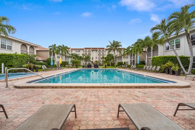 a view of swimming pool with outdoor seating and house in the background