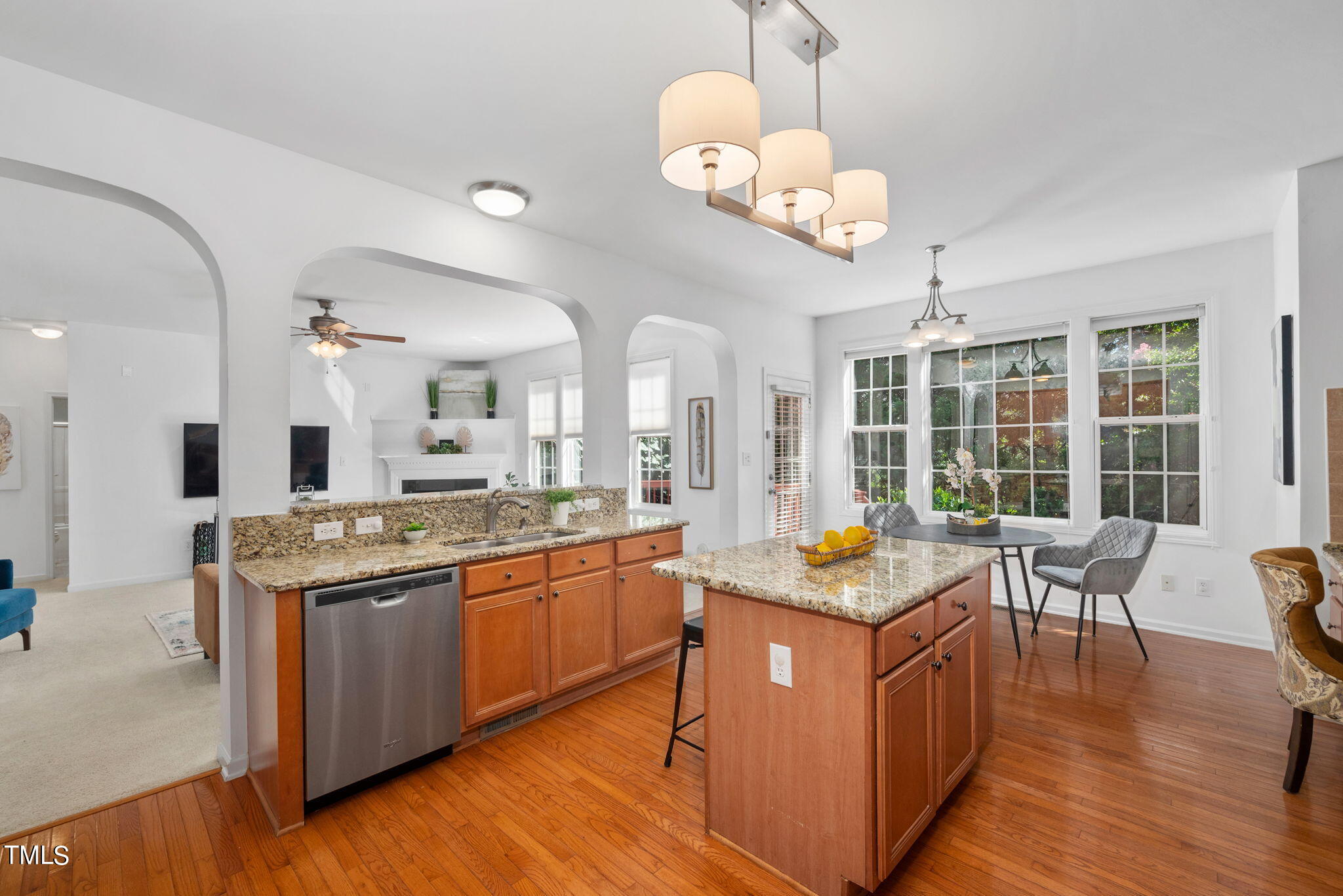 8405 Dunnington Circle Raleigh, NC 27613 - Photo 17 of 50 a open kitchen with stainless steel appliances granite countertop a stove top oven a dining table and chairs with wooden floor