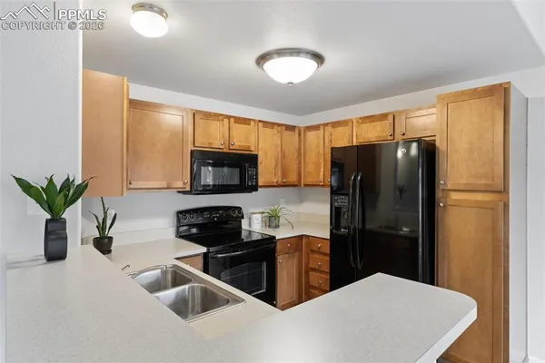 a kitchen with stainless steel appliances granite countertop a refrigerator a sink a stove a microwave and cabinets