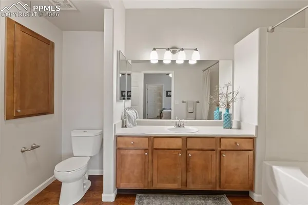 a bathroom with a granite countertop sink a toilet and a mirror