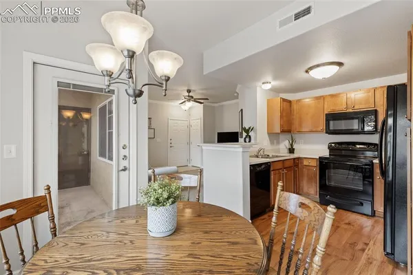 a kitchen view with stainless steel appliances a refrigerator and a chandelier