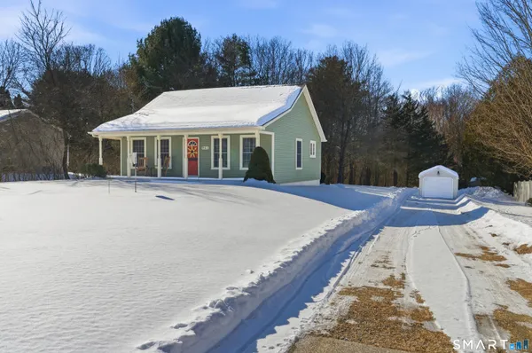 a front view of house with yard and trees around