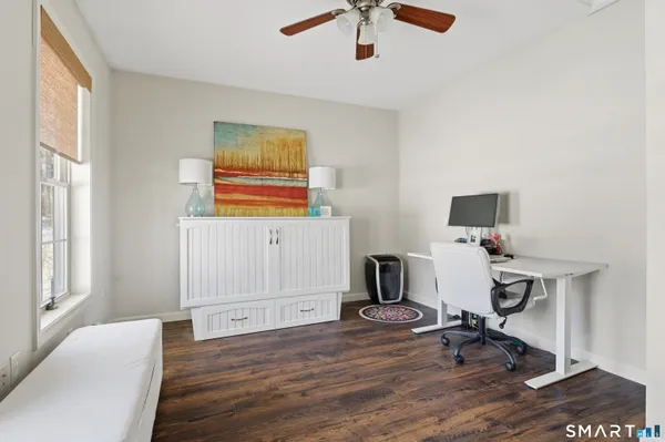 a view of a workspace with furniture and a window