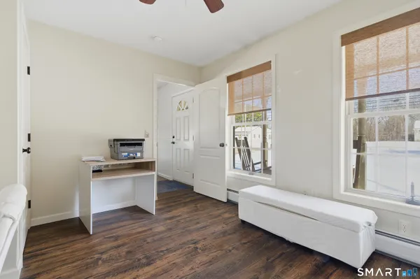 a living room with stainless steel appliances wooden floor and a window