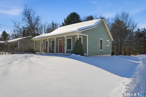 a view of house with yard and trees in the background