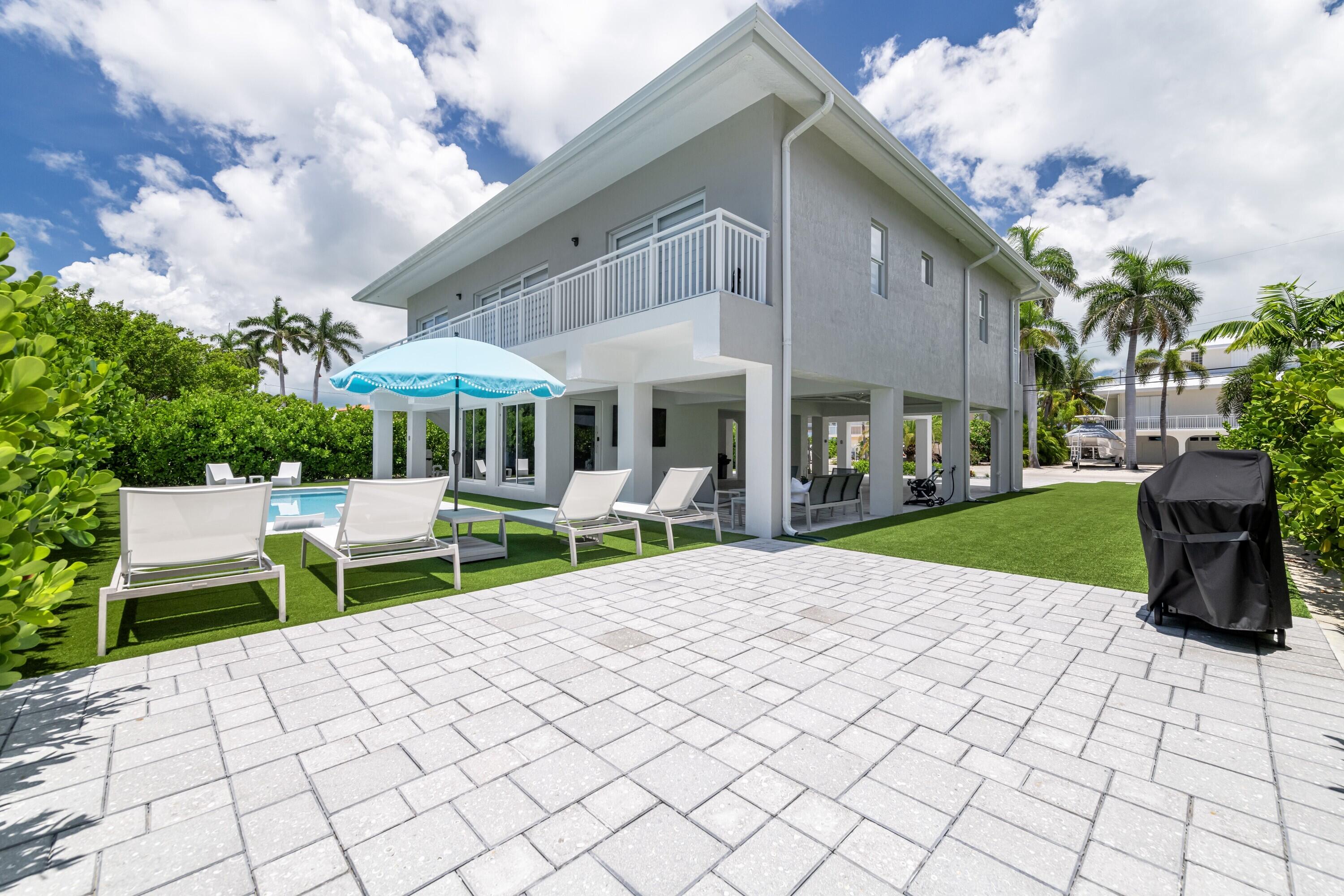 227 Corsair Road Marathon, FL 33050 - Photo 11 of 66 a view of a patio with table and chairs under an umbrella