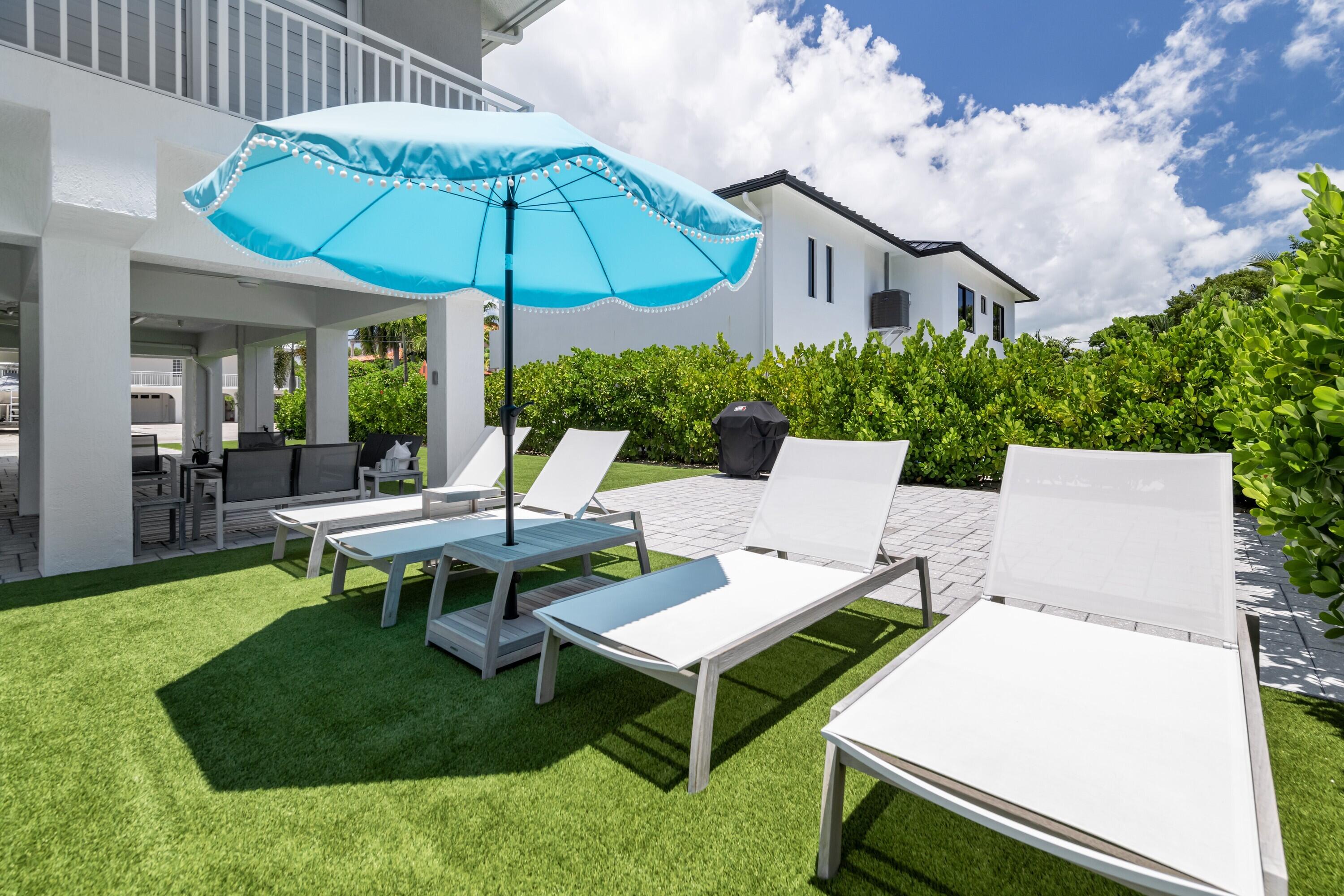 227 Corsair Road Marathon, FL 33050 - Photo 15 of 66 a view of a patio with a table and chairs under an umbrella