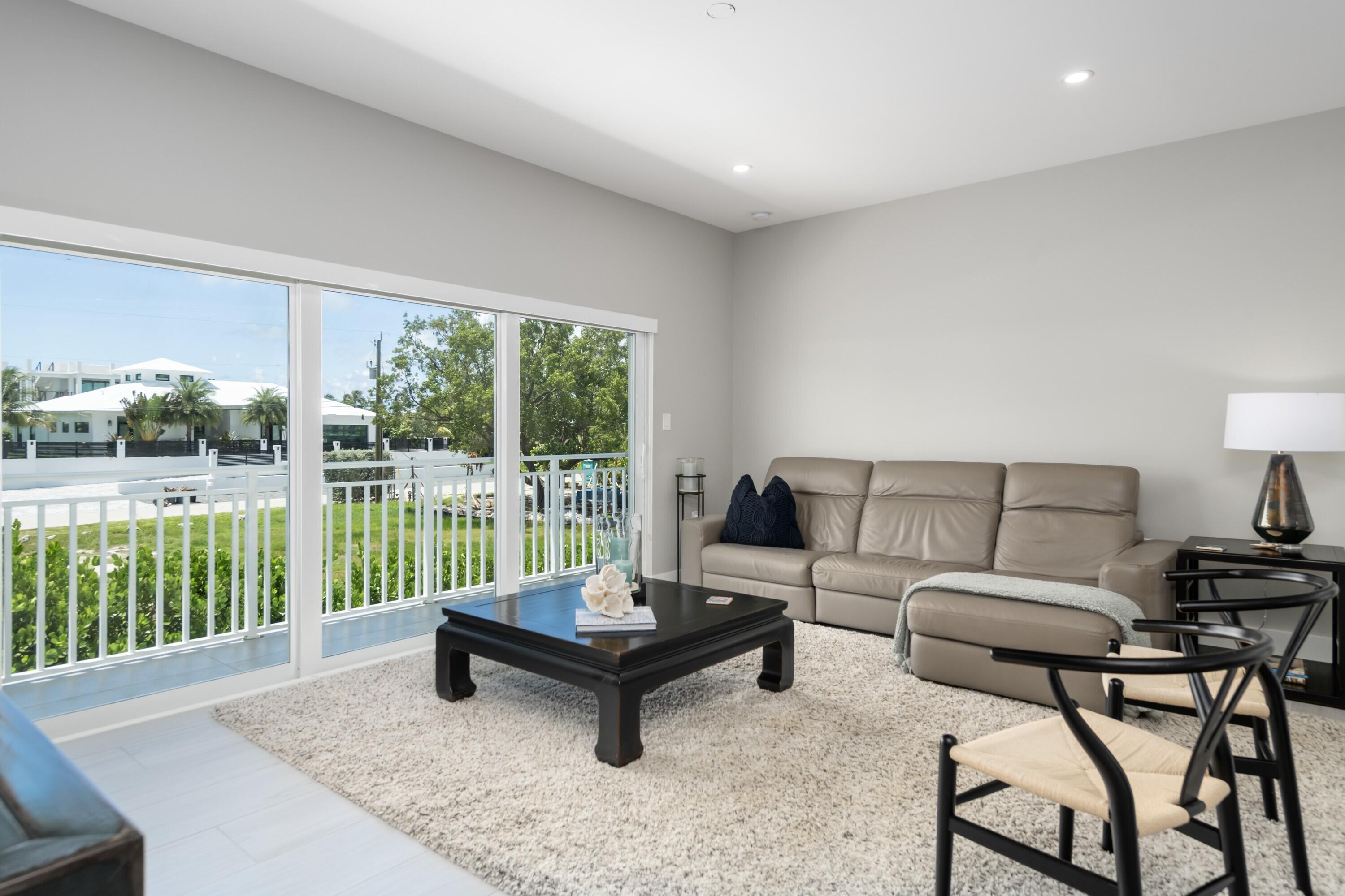 227 Corsair Road Marathon, FL 33050 - Photo 25 of 66 a living room with furniture and a floor to ceiling window
