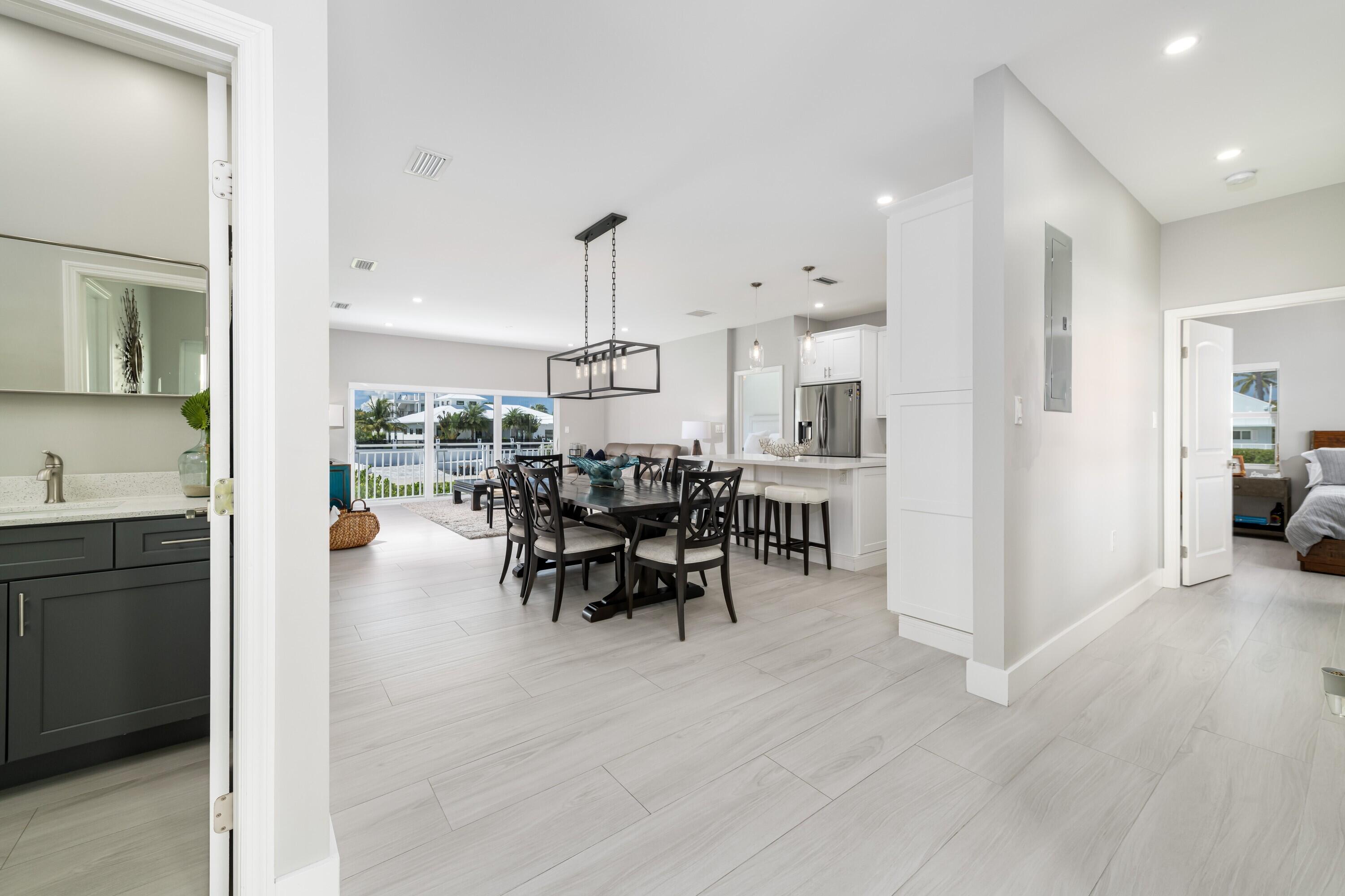227 Corsair Road Marathon, FL 33050 - Photo 34 of 66 a view of a dining room and livingroom with furniture wooden floor a rug a fireplace and a painting