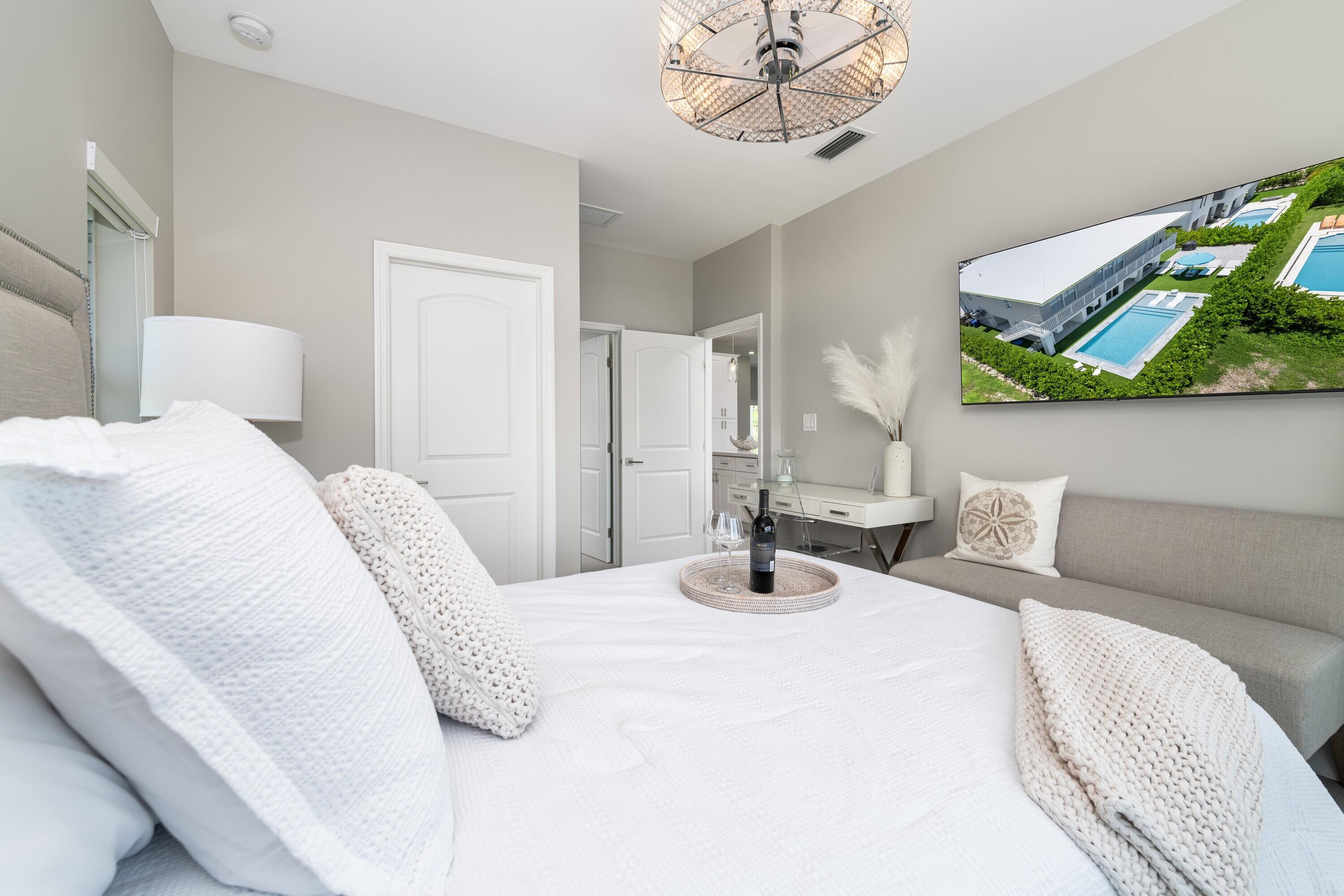 227 Corsair Road Marathon, FL 33050 - Photo 39 of 66 a bedroom with a bed a chandelier and a mirror