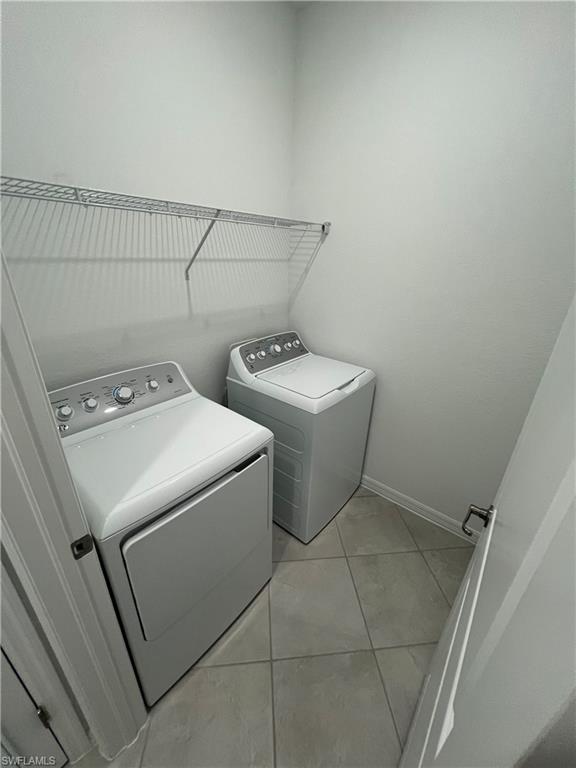 2320 Dragonfruit Way Naples, FL 34120 - Photo 21 of 33 Clothes washing area featuring light tile patterned flooring, baseboards, washer and dryer, and laundry area