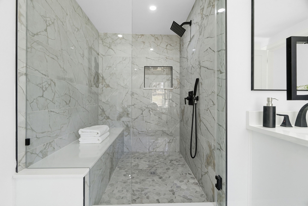 171 Shaw Road Brookline, MA 02467 - Photo 19 of 42 a bathroom with a granite countertop sink a toilet and shower