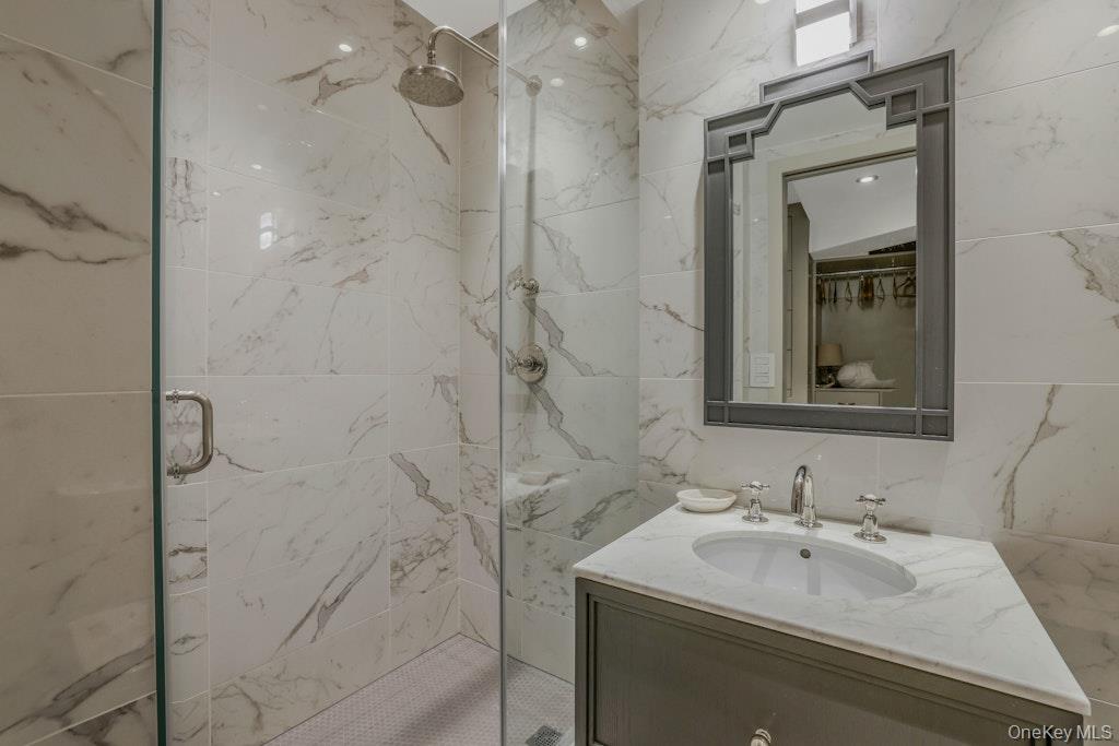 155 West 15th Street, Unit 1E Manhattan, NY 10011 - Photo 17 of 29 a bathroom with a sink mirror and shower