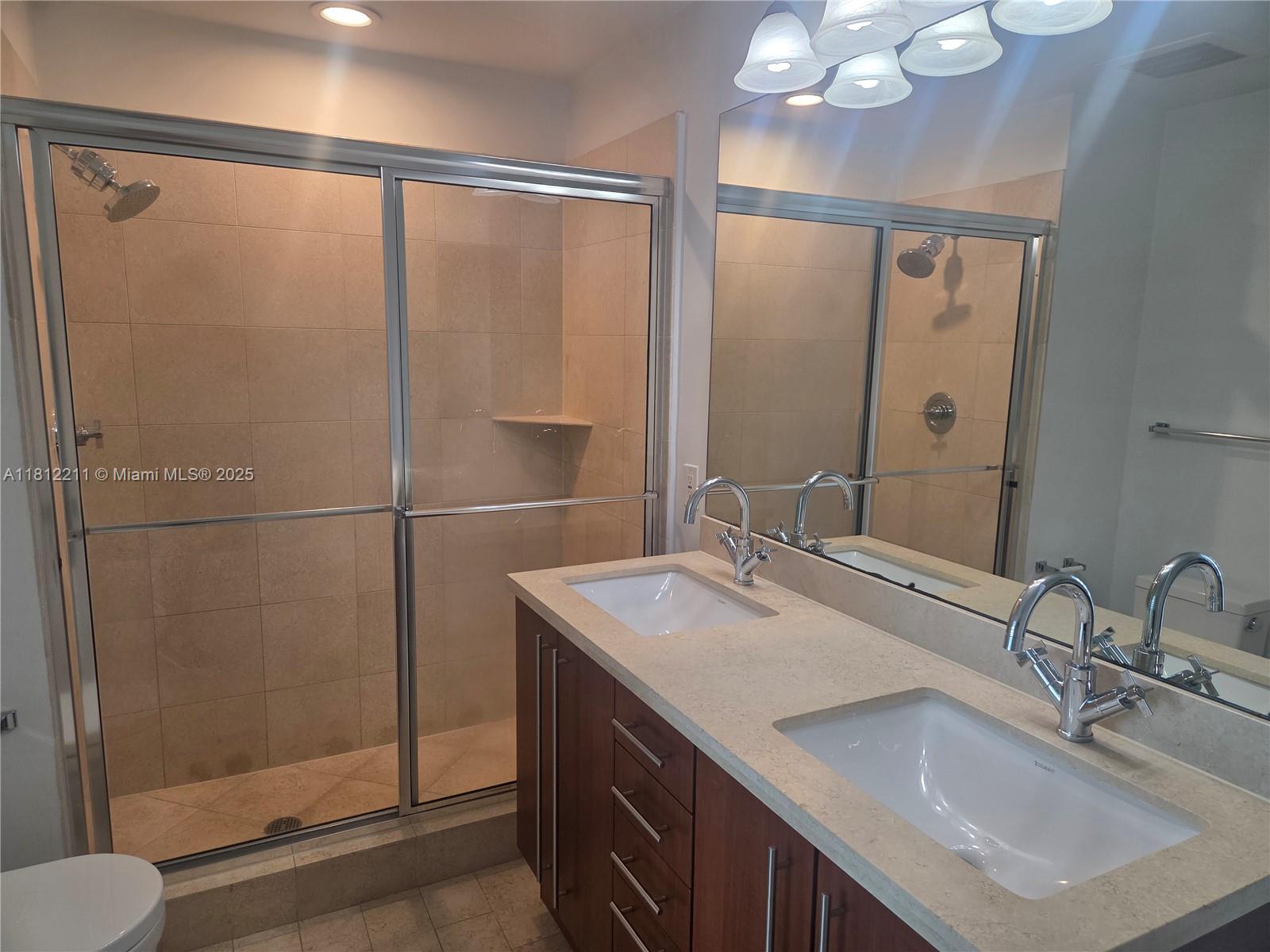 79 Southwest 12th Street, Unit 2409 Miami, FL 33130 - Photo 9 of 13 a bathroom with a sink and a mirror