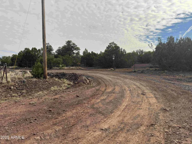 a view of dirt road with a building in the background