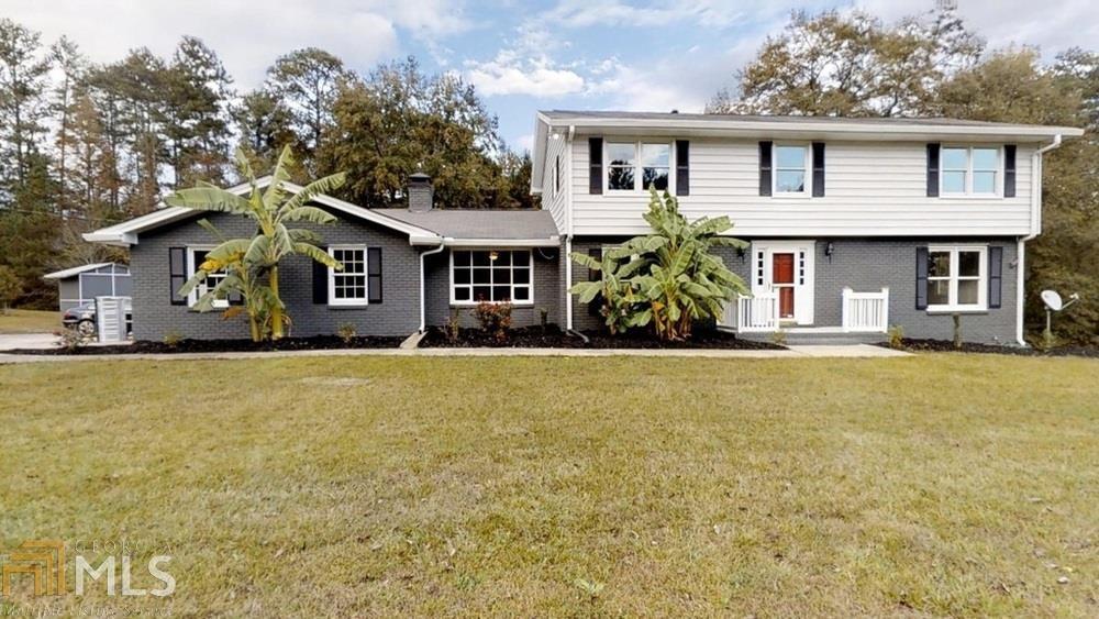 8665 Clark Road Fairburn, GA 30213 - Photo 1 of 1 a front view of a house with large trees