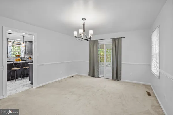 a dining room with furniture and a floor to ceiling window