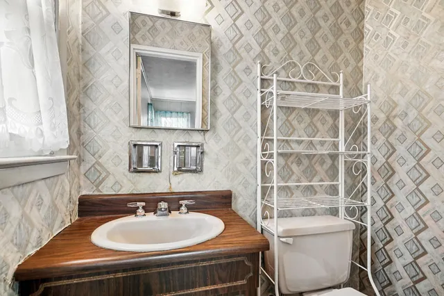 a bathroom with a sink and a mirror with toilet