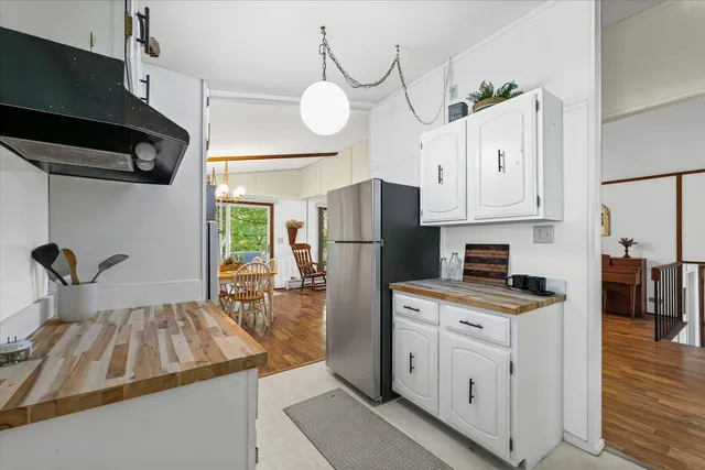 a kitchen with a refrigerator a stove a sink and white cabinets
