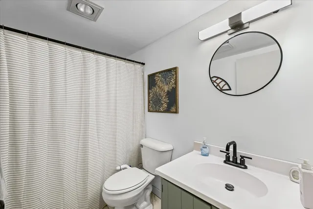 a bathroom with a sink mirror and toilet