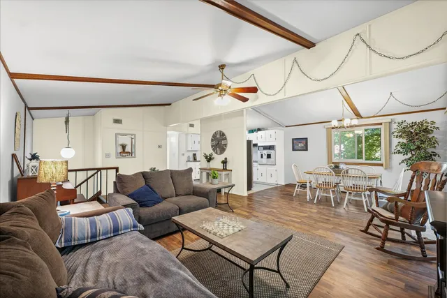 a living room with furniture a table and wooden floor