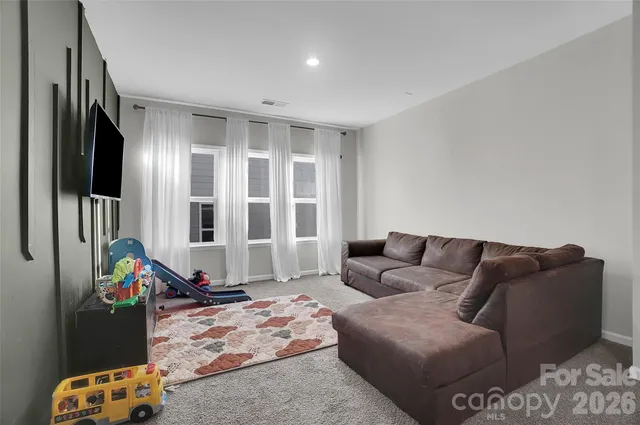 a spacious bedroom with a bed and a chandelier