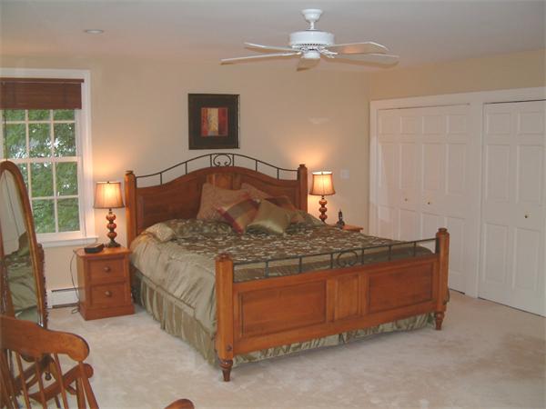 5 Berwick Road Lexington, MA 02420 - Photo 8 of 9 a bedroom with a bed and a chandelier