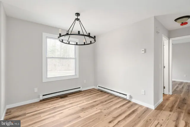 a view of a room with a window and wooden floor