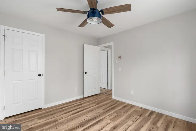 a view of room with wooden floor and ceiling fan