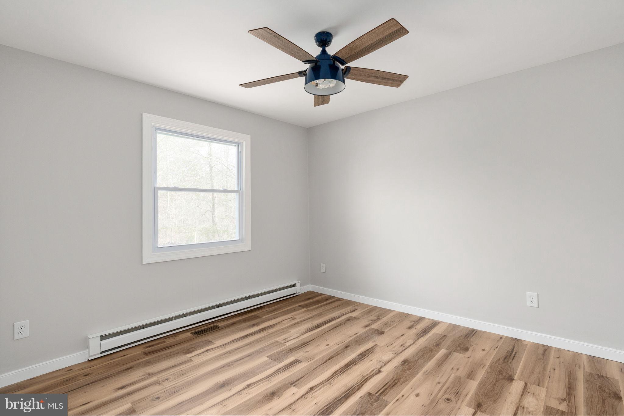 2174 Copper Line Road Bumpass, VA 23024 - Photo 24 of 45 an empty room with wooden floor and ceiling fan