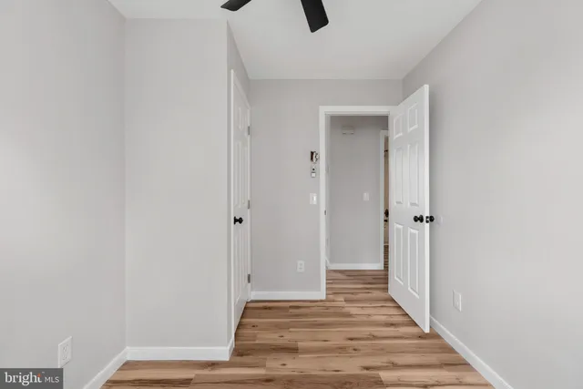 a view of a hallway with wooden floor and closet