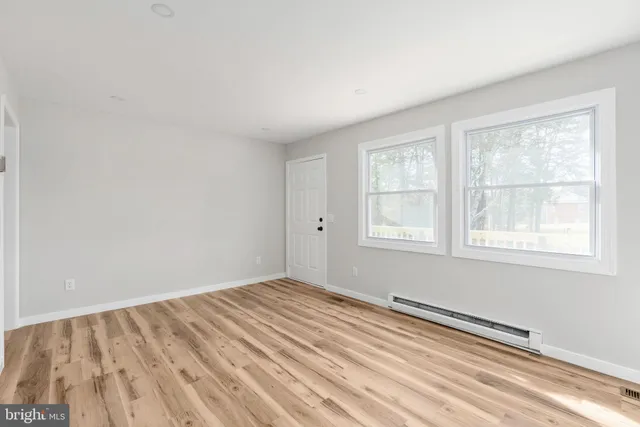 a view of a room with wooden floor and windows