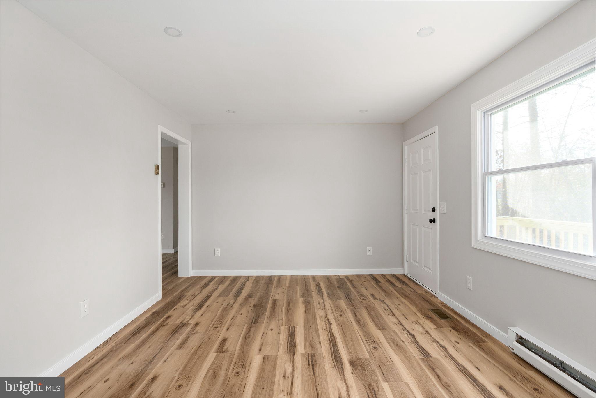 2174 Copper Line Road Bumpass, VA 23024 - Photo 5 of 45 an empty room with wooden floor and windows