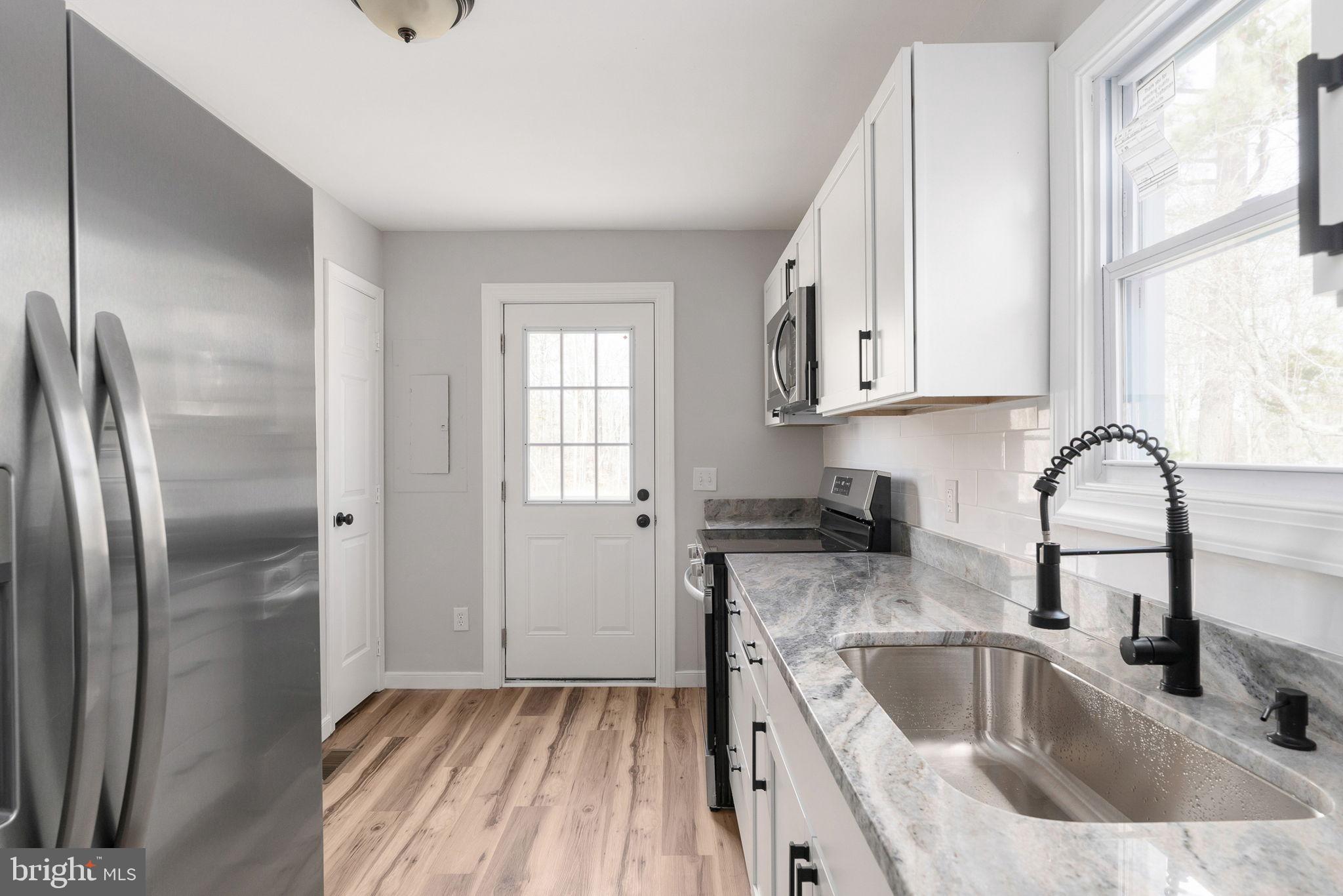 2174 Copper Line Road Bumpass, VA 23024 - Photo 7 of 45 Modern kitchen with sleek finishes.