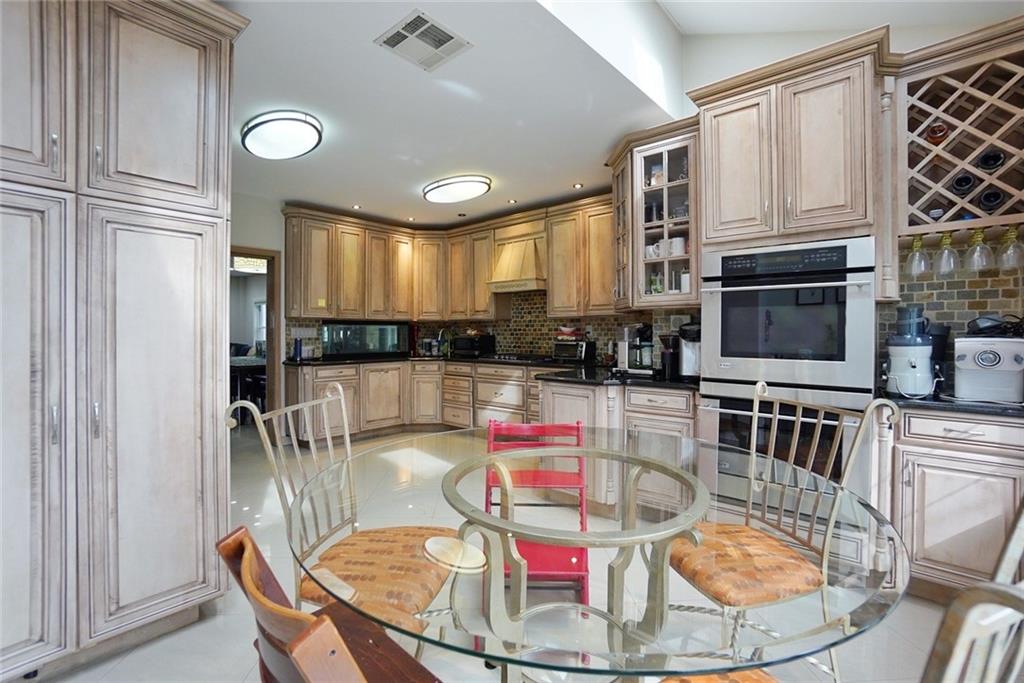 914 Avenue L Brooklyn, NY 11230 - Photo 14 of 27 a kitchen with stainless steel appliances granite countertop a refrigerator a stove a sink dishwasher with a dining table and chairs