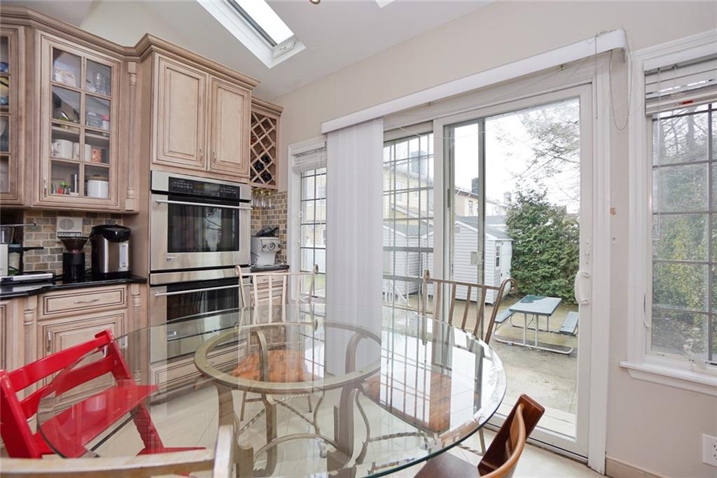 914 Avenue L Brooklyn, NY 11230 - Photo 15 of 27 a kitchen with stainless steel appliances granite countertop a stove a refrigerator a dining table and chairs with wooden floor