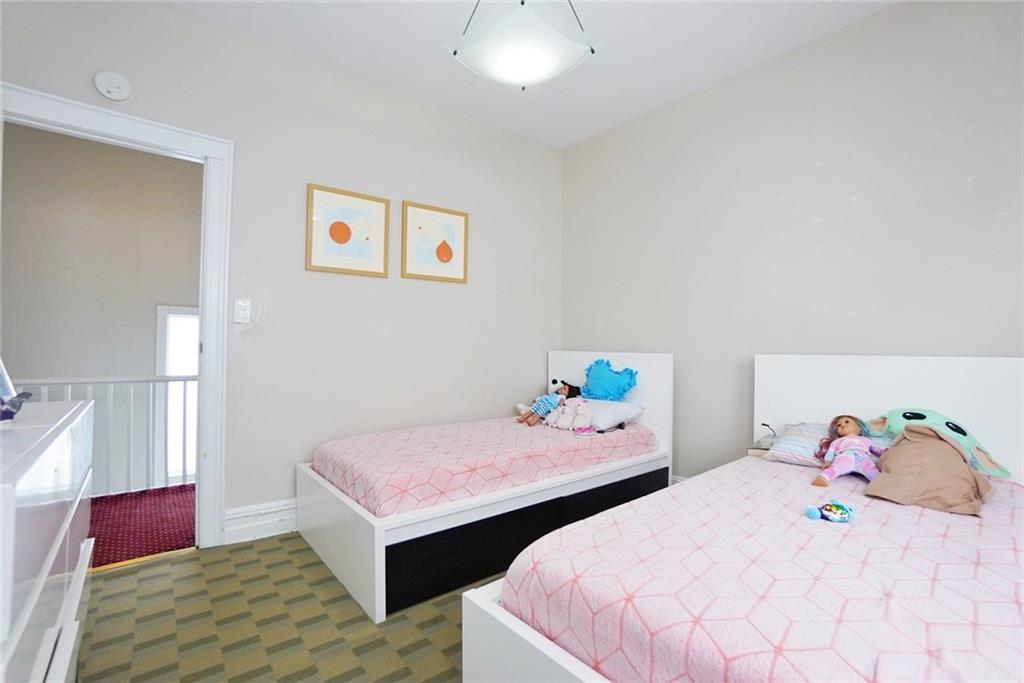 914 Avenue L Brooklyn, NY 11230 - Photo 20 of 27 a bedroom with two beds and a chandelier