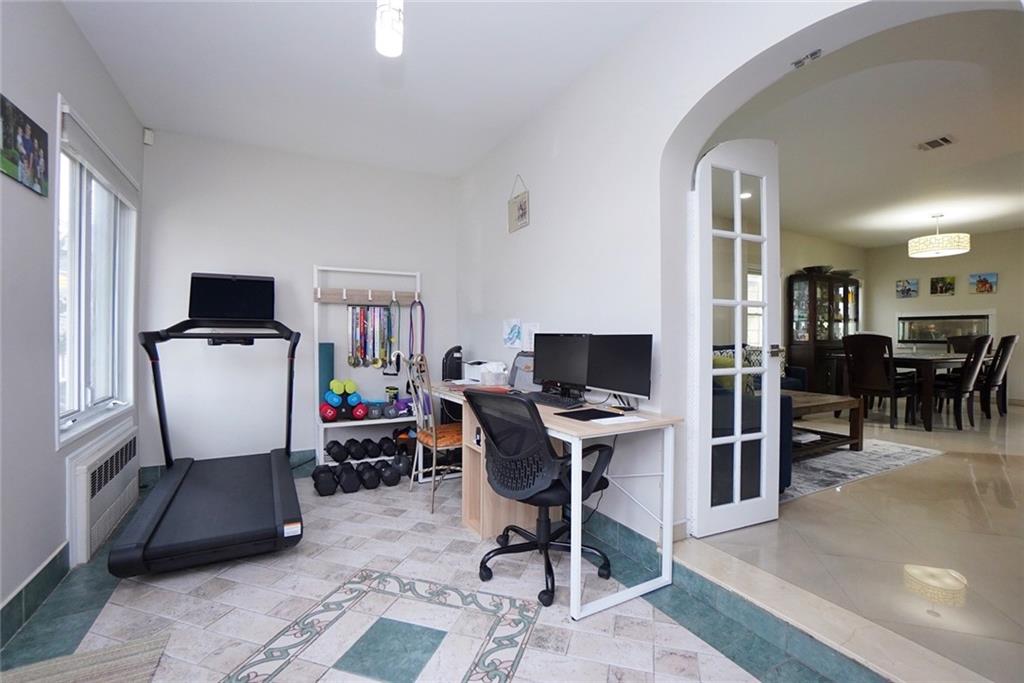 914 Avenue L Brooklyn, NY 11230 - Photo 6 of 27 a view of a workspace with furniture and a flat screen tv